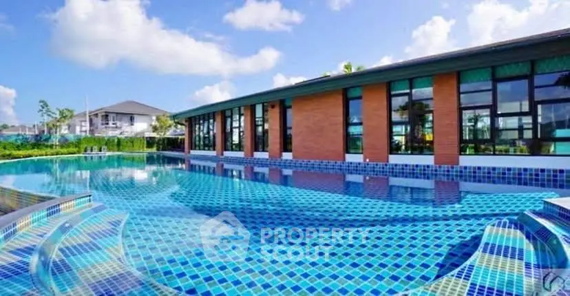 Luxurious poolside view with modern architecture and clear blue skies.