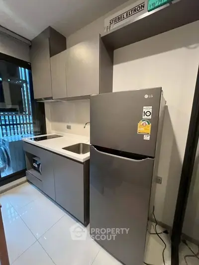 Modern kitchen with sleek cabinets and stainless steel appliances in a compact layout.