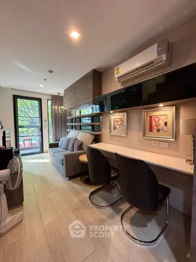Modern living room with stylish decor and natural light, featuring a cozy sofa and elegant workspace.