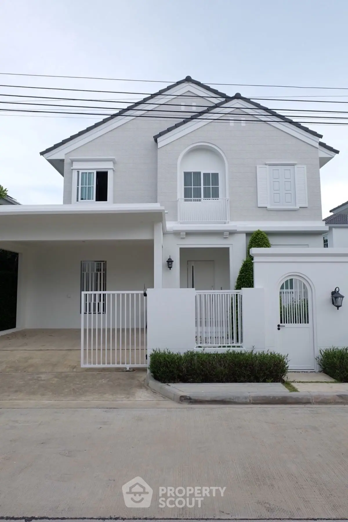 Charming two-story white house with modern design and gated entrance in a serene neighborhood.