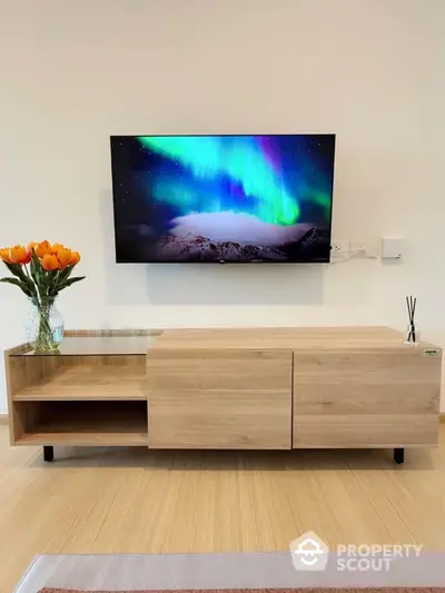 Modern living room with sleek wooden TV stand and vibrant wall-mounted screen