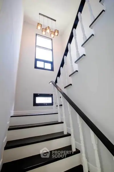 Elegant staircase with modern lighting and sleek black handrail