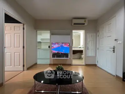 Modern living room with TV, air conditioning, and open kitchen view