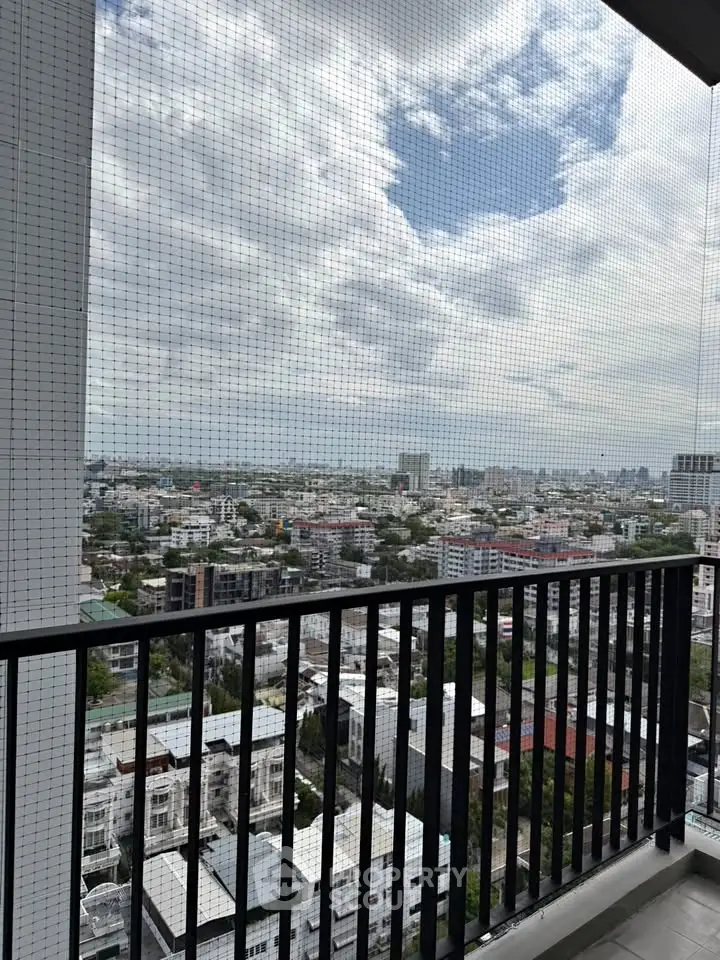 Stunning cityscape view from a high-rise balcony with safety netting, perfect for urban living enthusiasts.