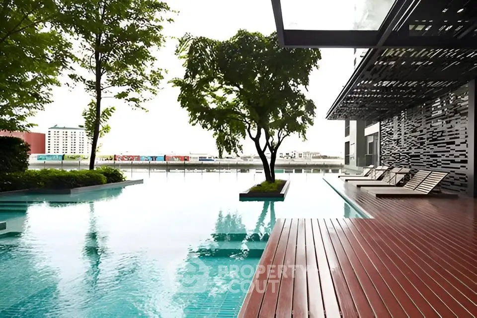 Luxurious modern poolside area with sleek wooden deck and lush greenery, perfect for relaxation and leisure.