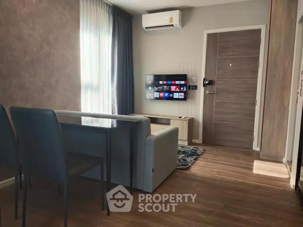 Modern living room with sleek furniture and wall-mounted TV, featuring elegant wooden flooring and natural light.
