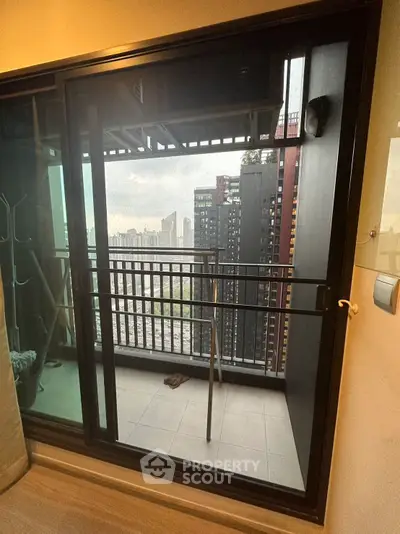 Modern apartment balcony with city view and sleek glass door
