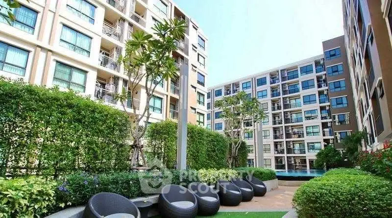Modern apartment complex with lush garden and outdoor seating area
