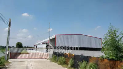 Spacious industrial warehouse with secure gated entrance and ample outdoor space.