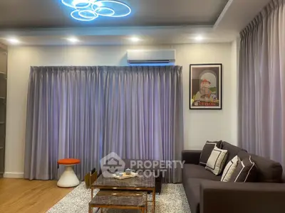Modern living room with stylish decor, cozy seating, and elegant lighting