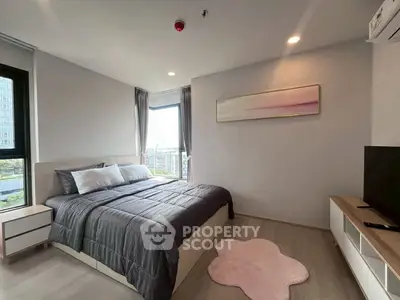 Modern bedroom with large windows and stylish decor in a high-rise apartment.