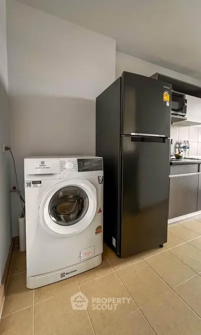 Modern kitchen with sleek black fridge and washing machine, perfect for urban living.