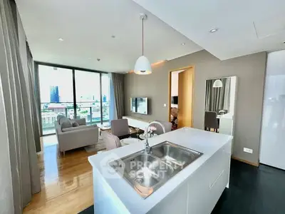 Modern open-plan living room with city view, featuring sleek kitchen island and stylish decor.