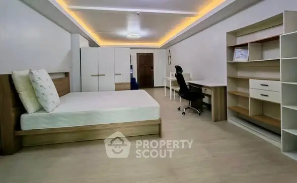 Spacious modern bedroom with sleek furniture and ample storage space.