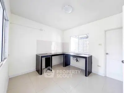 Spacious kitchen with modern black countertops and ample natural light.