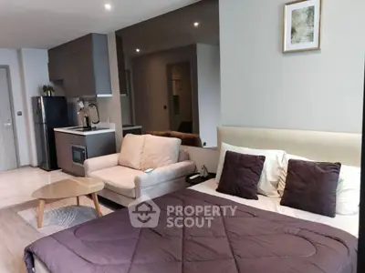 Modern studio apartment with cozy bed and stylish kitchen area