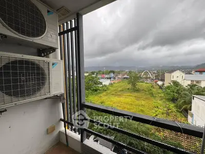 Spacious balcony with scenic view of lush greenery and cityscape, perfect for relaxation.
