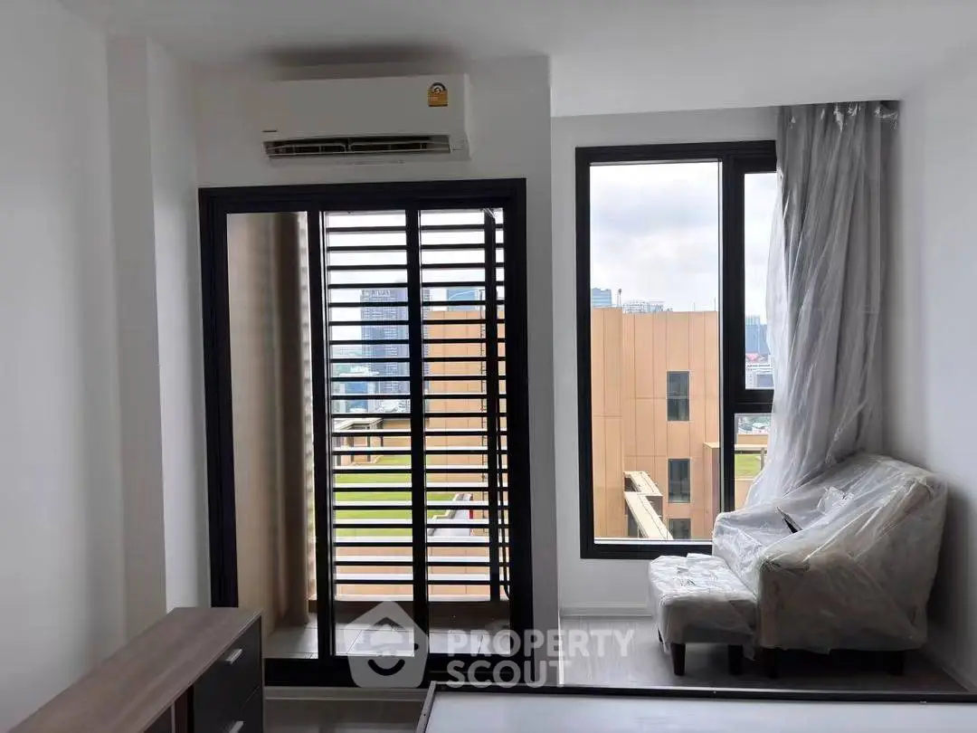 Modern apartment with large windows and balcony offering city views, featuring air conditioning and sleek design.