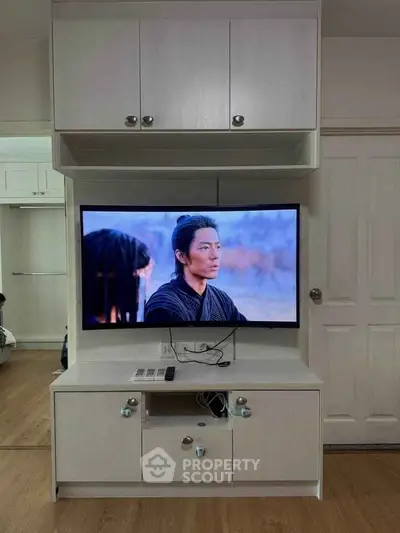 Modern living room with sleek TV stand and flat-screen TV, showcasing stylish interior design.