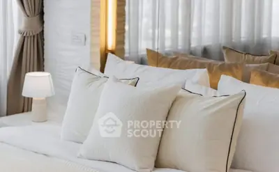 Luxurious bedroom with elegant decor and soft lighting, featuring plush pillows and stylish curtains.