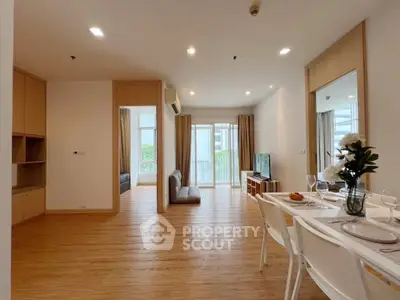 Spacious modern living room with dining area and balcony view