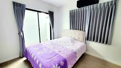 Cozy bedroom with elegant curtains and sliding glass door to balcony