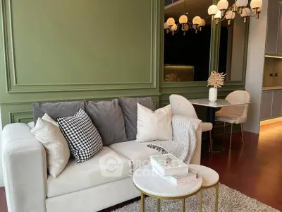 Elegant living room with stylish sofa, chic lighting, and cozy dining area in modern apartment.