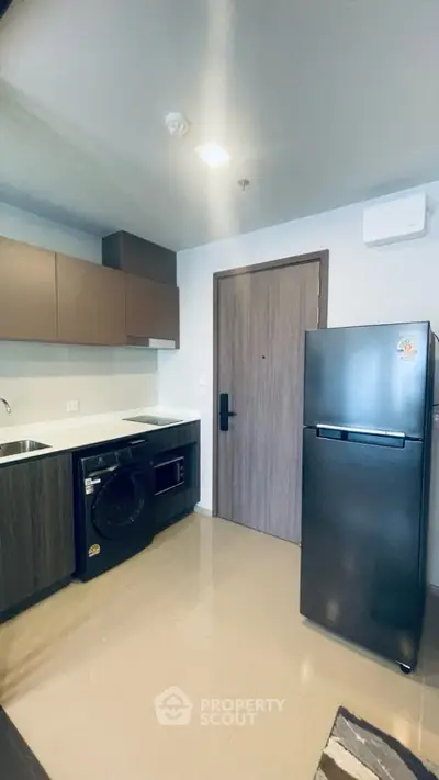 Modern kitchen with sleek appliances and stylish cabinetry in a contemporary apartment.