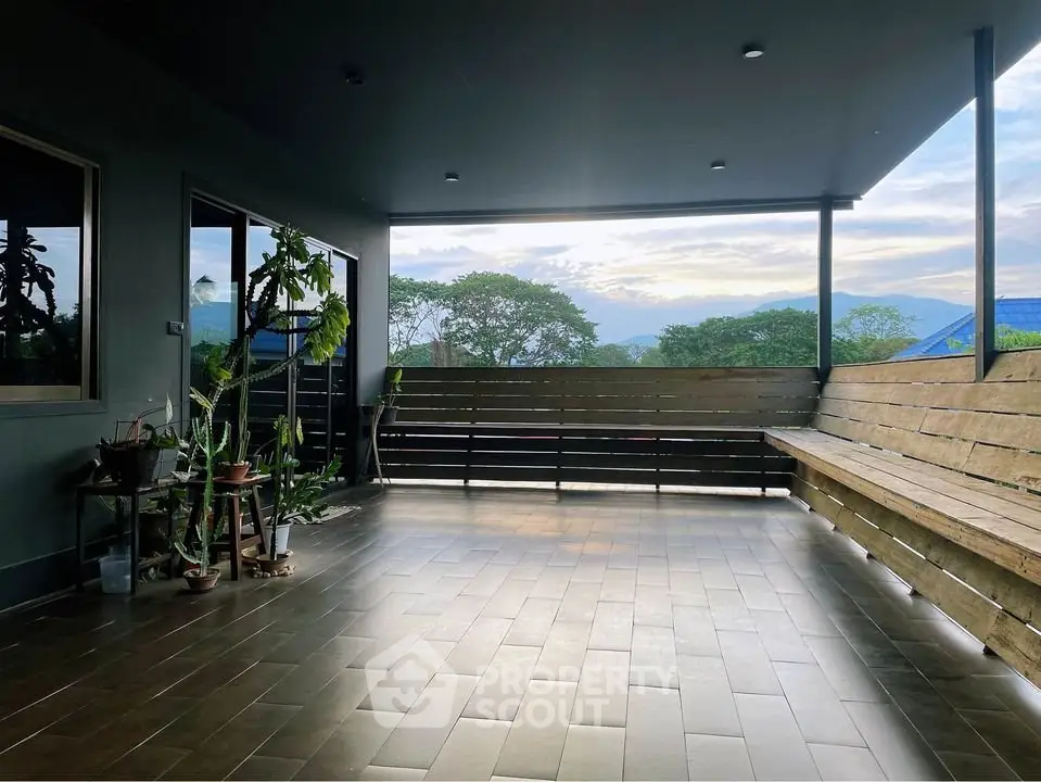 Spacious balcony with scenic mountain view and modern wooden seating.