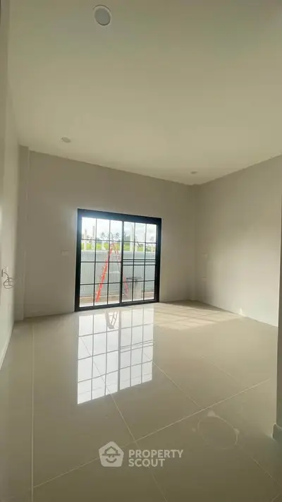 Spacious unfurnished room with large window and glossy tiled floor, perfect for customization.
