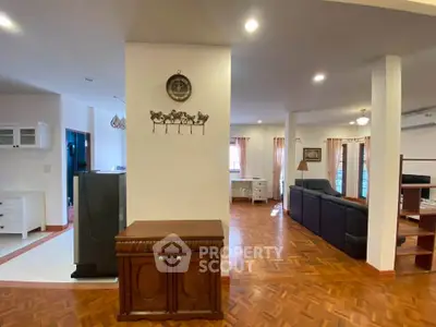 Spacious open-plan living area with elegant wooden flooring and stylish decor.