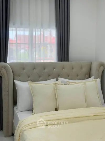 Luxurious bedroom with elegant tufted headboard and soft neutral bedding, perfect for relaxation.