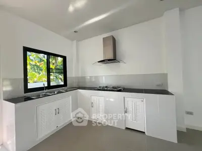 Modern kitchen with sleek design, featuring gas stove and ample natural light.