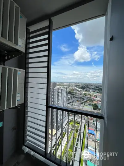 Stunning high-rise balcony view overlooking cityscape with clear blue skies.