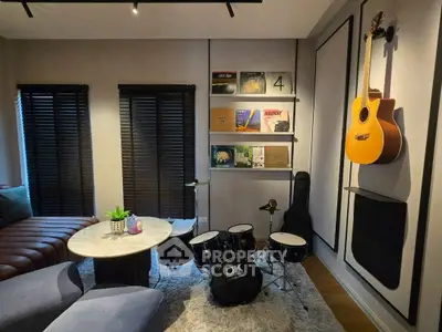 Stylish music-themed living room with drum set and guitar on wall, perfect for musicians.