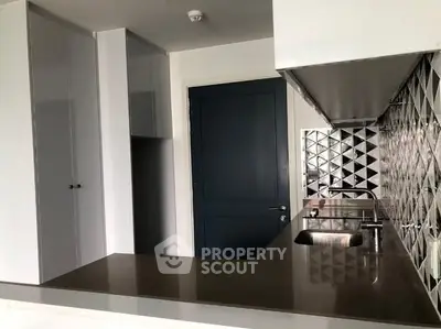 Modern kitchen with sleek countertops and geometric backsplash design