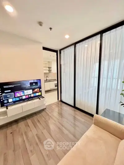 Modern living room with sleek TV setup and open kitchen layout