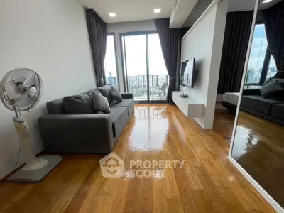 Modern living room with wooden floors, large windows, and city view in a high-rise apartment.
