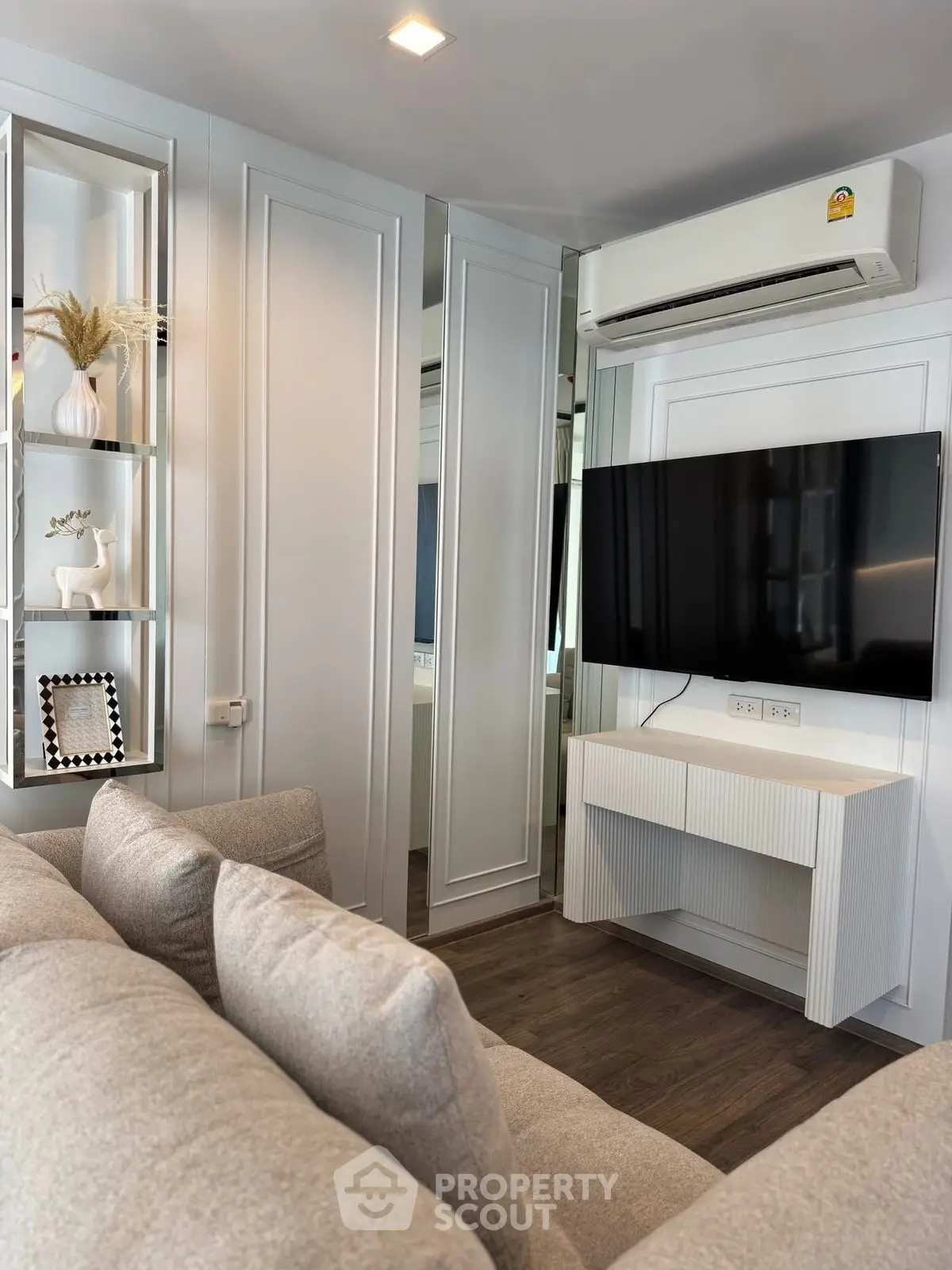 Modern living room with sleek design, featuring a wall-mounted TV and stylish decor.