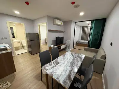 Modern open-plan living room with dining area, featuring stylish furniture and sleek design.