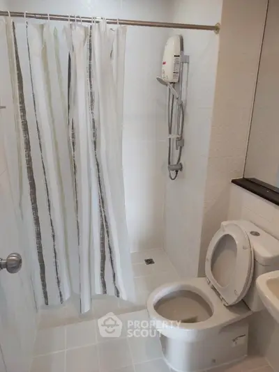 Modern bathroom with shower and toilet in a clean, tiled setting.