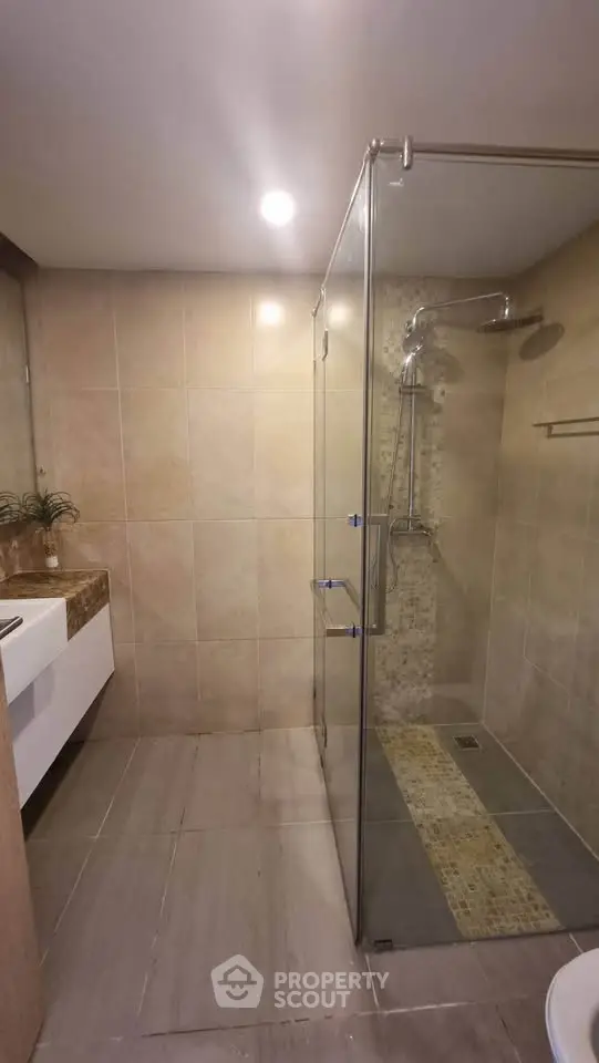 Modern bathroom with glass shower enclosure and elegant tile design