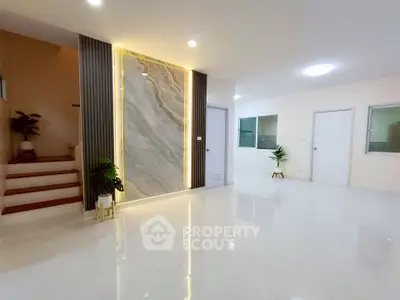 Spacious modern living room with elegant lighting and marble accent wall