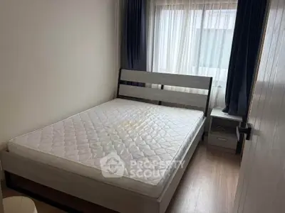 Cozy bedroom with natural light and modern furnishings in a stylish apartment.
