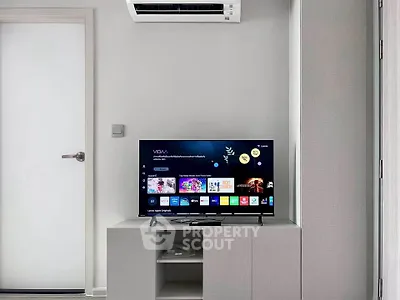 Modern living room with sleek TV setup and air conditioning unit.