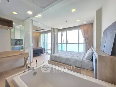 Luxurious open-plan bedroom with bathtub and stunning balcony view
