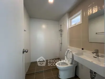 Modern bathroom with sleek fixtures and neutral tiles, featuring a spacious shower area.