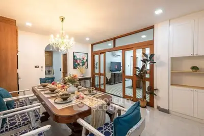 Elegant dining room with chandelier and stylish decor, open layout to living area, perfect for entertaining.