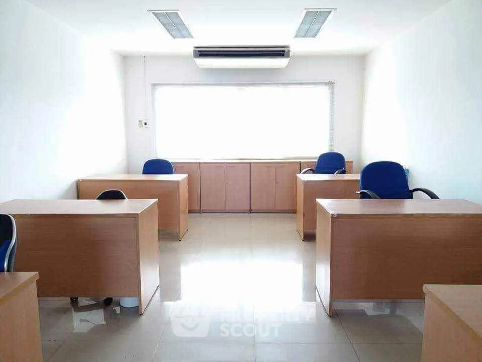 Spacious office space with modern desks and chairs, ample natural light, and air conditioning.