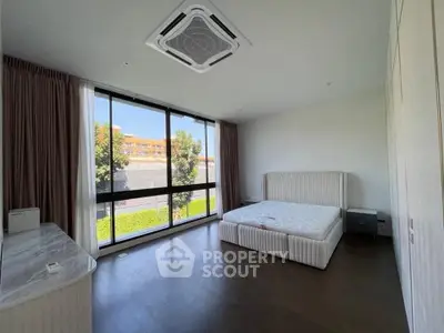 Spacious bedroom with large windows and modern design in a luxury apartment.